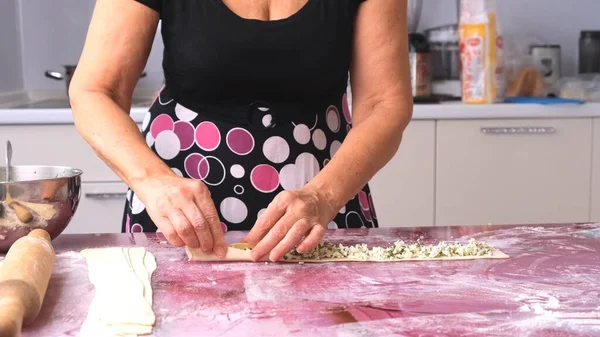 As mãos femininas fazem hambúrgueres, khachapuri com queijo e ervas da massa. o processo de fazer pães — Fotografia de Stock