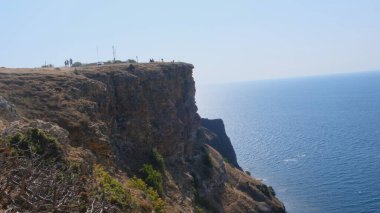 Sivastopol, Kırım 'daki Cape Fiolent plajında. Kayanın tepesinden bak. Mavi deniz, güneşli bir gün açık gökyüzü arka planı. Yaz seyahati ve dinlenme yeri konsepti.