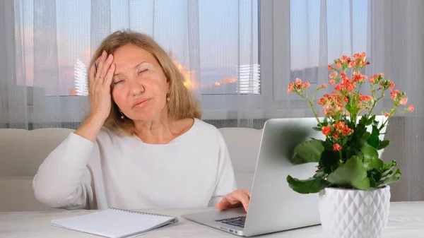 Donna stanca sul posto di lavoro, con la testa in mano. Sovraccarico di lavoro, errori, stress, depressione. — Foto Stock