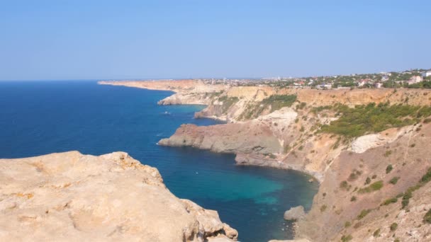 Baunty beach on cape Fiolent em Balaklava, Crimeia. Vista do topo da rocha. mar azul, dia ensolarado céu limpo fundo. O conceito de lugar perfeito para viagens de verão e descanso. — Vídeo de Stock