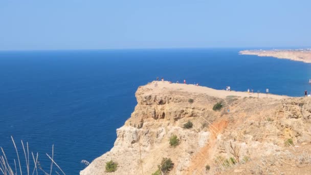 Praia na capa Fiolent em Sevastopol, Crimeia. Vista do topo da rocha. mar azul, dia ensolarado céu claro fundo. O conceito de lugar para viagens de verão e descanso. — Vídeo de Stock