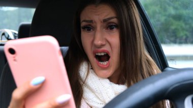 Araba sürerken akıllı telefon kullanan bir kadın şaşırdı. Kötü haber kavramı.
