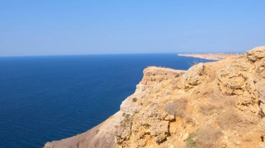 Sivastopol, Kırım 'daki Cape Fiolent plajında. Kayanın tepesinden bak. Mavi deniz, güneşli bir gün açık gökyüzü arka planı. Yaz seyahati ve dinlenme yeri konsepti.