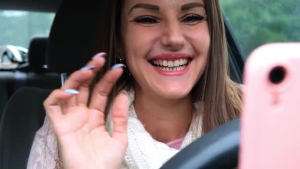 Joyful female using a smartphone on a car driving. Portrait of a cheerful woman looking at the phone while driving. — Stock Video