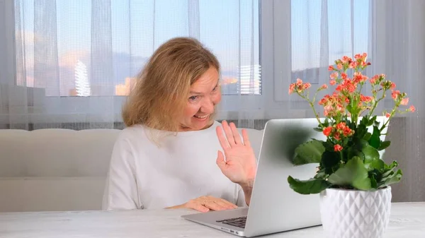Zâmbind o femeie elegantă cu un apel video pe un laptop. Conceptul de comunicare . — Fotografie, imagine de stoc
