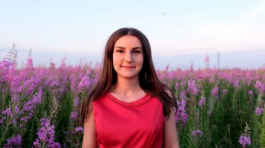 Gün batımında söğüt çayının içinde genç bir esmerin portresi. Parlak, güneşli bir akşamda, ateş otu saplı kız.