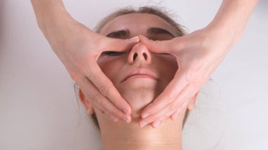 Güzel bir kızın güzellik kliniğinde yüz masajı var. konsept cilt bakımı, spa konsepti, tedavi, yüz masajı