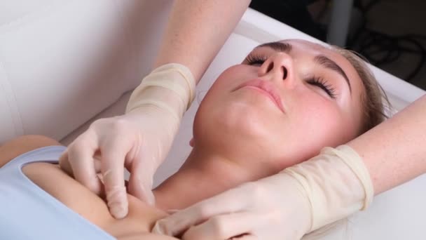 El masaje de barbilla de la mujer joven durante el masaje facial en el salón de belleza — Vídeos de Stock