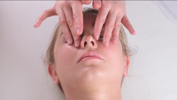 Krásná žena v salonu s masáž obličeje. — Stock video