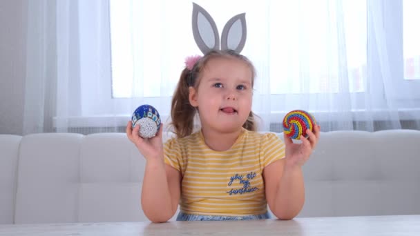 Feliz niño alegre en orejas de conejo y con huevos de color Pascua — Vídeos de Stock