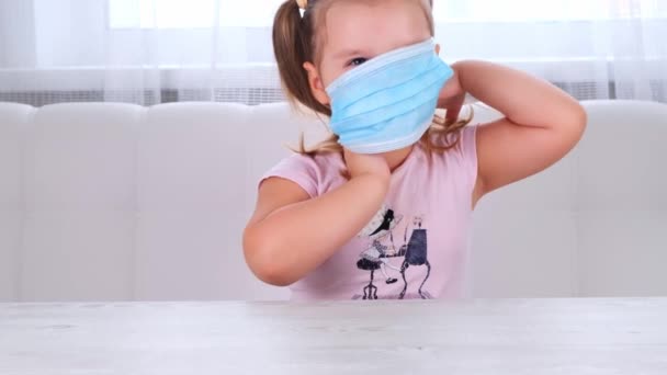 Küçük kız koronavirüs ve çeşitli enfeksiyonlara karşı koruyucu bir maske takıyor. Karantina, hastalık.... — Stok video