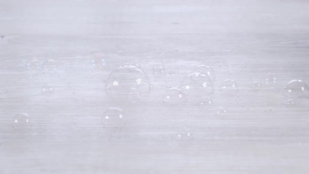 Burbujas de jabón arco iris en una mesa de madera blanca. Concepto de relajación e imaginación, infancia — Vídeos de Stock