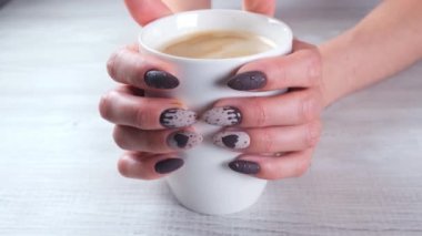 Manikürlü güzel tırnaklar, kadın eli çikolatalı şekerler ve bir fincan kahve..