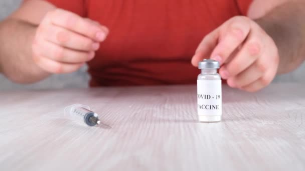 Injektionsflaskor med vaccin mot coronavirus, influensa och farliga sjukdomar samt en spruta och manliga händer. Corona virus, influensa, injektioner, sprutor och kliniska prövningar behandlingskoncept under pandemi — Stockvideo