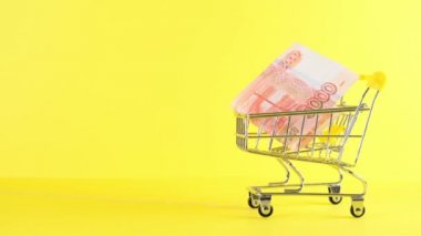 Sarı arka planda beş bin Rus rublesi olan alışveriş arabası, yakın plan. Kara Cuma Alışveriş ve İndirim Konsepti