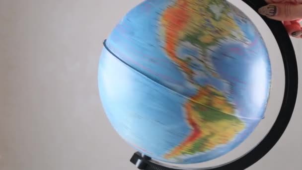 Model globusu se otáčí na dřevěném stole. Bílá zeď prázdný prostor pozadí: Moskva, Rusko - Únor 25, 2021 — Stock video