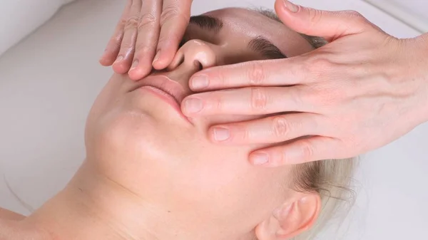 Bella donna in salone con massaggio facciale. — Foto Stock