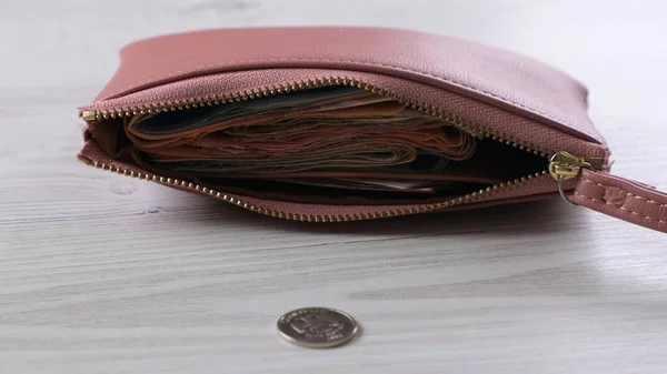 Бумажник лежит на столе рядом с монетой. Концепция финансов, доходов и расходов, наличный расчет. — стоковое фото