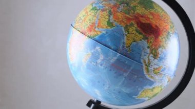 Tahta masada dönen dünya modeli. Beyaz duvar boş alan arkaplanı: Moskova, Rusya - 25 Şubat 2021