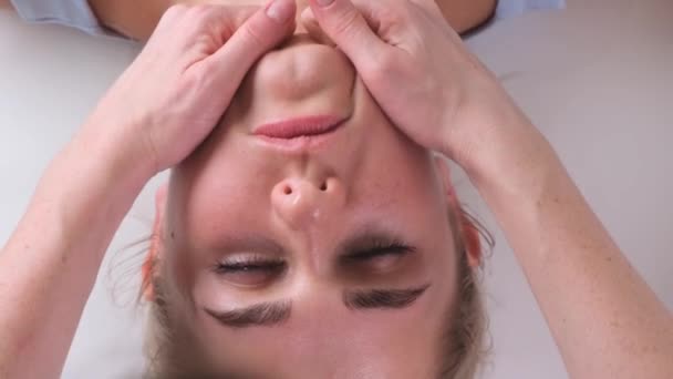 Massage du menton de femme jeune femme pendant le massage du visage au salon de beauté — Video