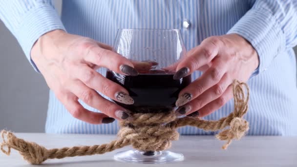 Mains féminines tenant verre à vin est attaché avec une corde de jute. Le concept de dépendance à l'alcool. Le problème du traitement de l'alcoolisme — Video