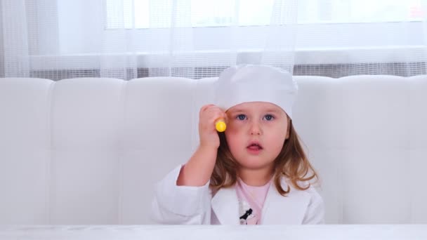 Mała dziewczynka bawi się w lekarza, robi zastrzyk. Koncepcja leczenia wirusami korony, wstrzyknięcie podczas pandemii — Wideo stockowe