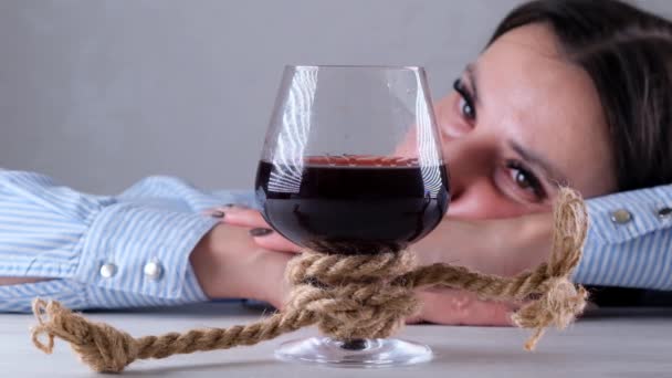 Triste mujer mirando copa de vino atado con cuerda de yute. El concepto de adicción al alcohol. El problema del tratamiento del alcoholismo — Vídeos de Stock