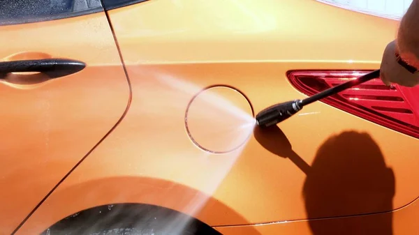 Lavagem manual do carro com água pressurizada na lavagem do carro fora no verão. — Fotografia de Stock