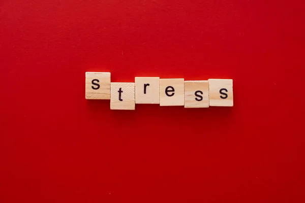 Word STRESS made of wooden letters on red background with copy space — Stock Photo, Image