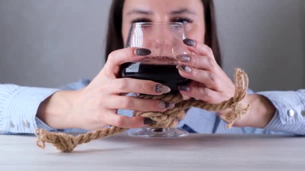 Triste mujer mirando copa de vino atado con cuerda de yute. El concepto de adicción al alcohol. El problema del tratamiento del alcoholismo — Vídeo de stock