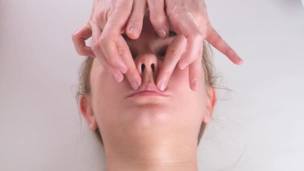 El masaje de barbilla de la mujer joven durante el masaje facial en el salón de belleza — Vídeo de stock