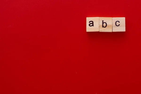 Mot ABC fait de lettres en bois sur fond rouge avec espace de copie — Photo