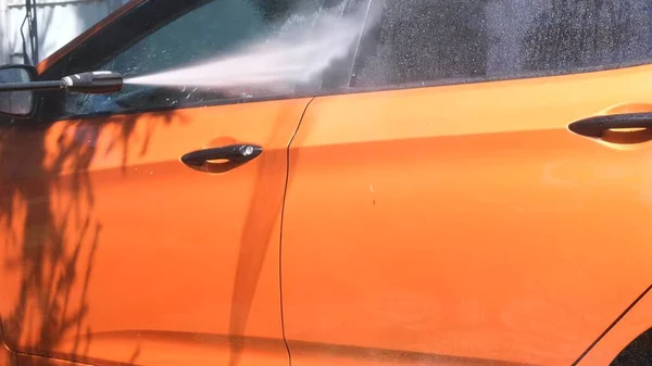 Lavagem manual do carro com água pressurizada na lavagem do carro fora no verão. — Fotografia de Stock
