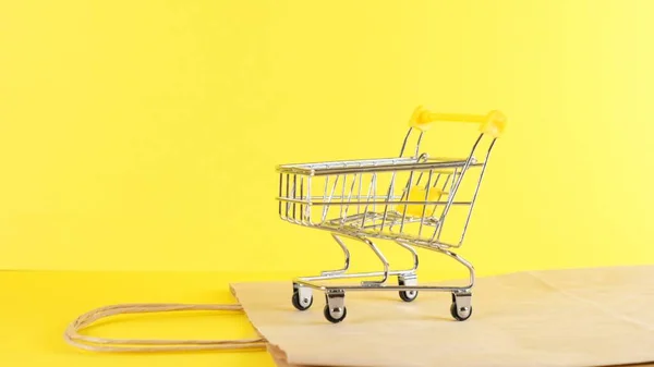 Carrello vuoto su sfondo giallo, primo piano. Venerdì nero Shopping e Sconto Concetto — Foto Stock