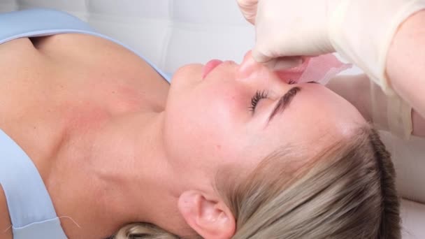 Schöne Mädchen hat eine Gesichtsmassage in einer Schönheitsklinik. Gesichtspflegekonzept . — Stockvideo