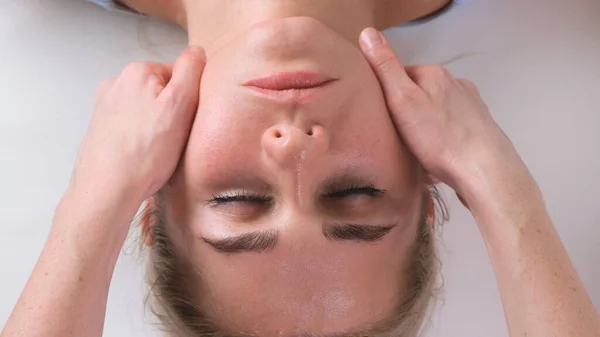 Massagem de queixo de mulher jovem durante a massagem facial no salão de beleza — Fotografia de Stock
