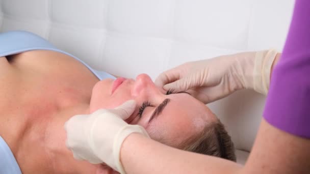 Masaż brody młodej kobiety podczas masażu twarzy w salonie piękności — Wideo stockowe