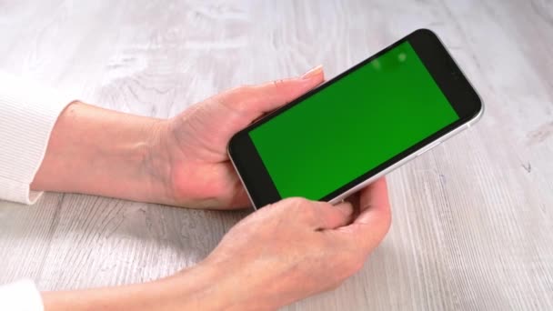 Contactless nel nuovo concetto normale da donna di mezza età senior hold and use smart phone with green screen: Mosca, Russia - 24 giugno 2021. — Video Stock