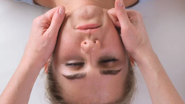 El masaje de barbilla de la mujer joven durante el masaje facial en el salón de belleza —  Fotos de Stock