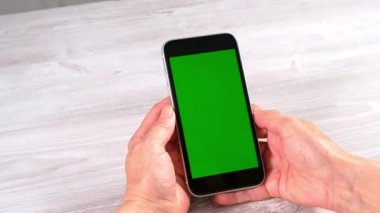 Orta yaşlı kadın senyora, krom ekranlı iPhone akıllı telefonu kullanıyor. Kopya uzayı. Çevrimiçi alışveriş kavramı, mobil uygulamaların kullanımı: Moskova, Rusya - 24 Haziran 2021.