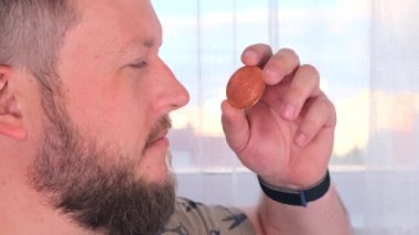 Elinde altın bir bitcoin tutan bir adamın portresi. Madencilik, kripto para birimi, madencilik ve elektronik parayla yerleşim.