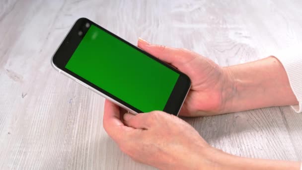 Orta yaşlı kadınlardan yeni normal konseptte ulaşılamıyor ve yeşil ekranlı akıllı telefon kullanılıyor: Moskova, Rusya - 24 Haziran 2021. — Stok video
