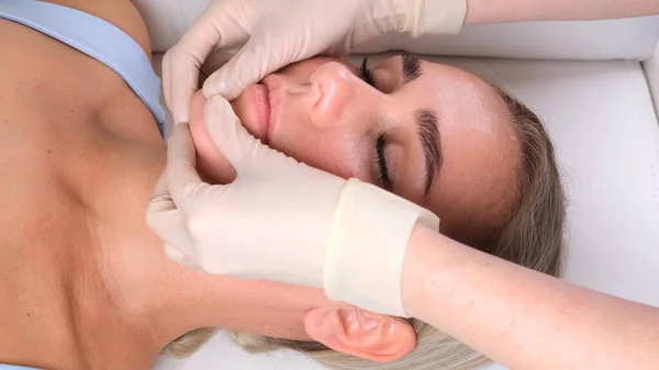 El masaje de barbilla de la mujer joven durante el masaje facial en el salón de belleza — Foto de Stock