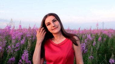 Gün batımında söğüt çayının içinde genç bir esmerin portresi. Parlak, güneşli bir akşamda, ateş otu saplı kız.