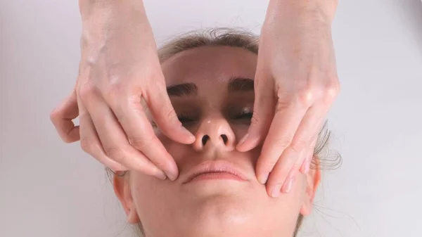 Hermosa mujer en el salón teniendo masaje facial. —  Fotos de Stock