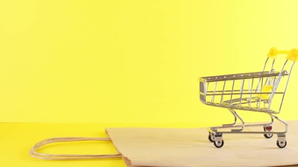Vazio Carrinho de compras em um fundo amarelo, close up. Black Friday Shopping e Conceito de Desconto — Vídeo de Stock
