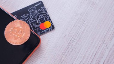 Bitcoin altın sikke ve modern bir akıllı telefon ekranının üzerinde duran bir kredi kartı. BTC engelleme zinciri ödemeleri, taşınabilir depolama ve ödeme, şifreli para birimi soyut kavramı ile ödeme: