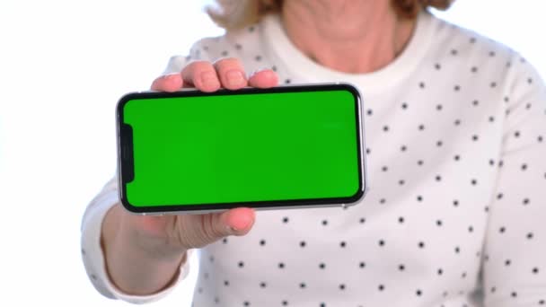 Weibliche Senora mittleren Alters benutzt ein iPhone-Smartphone mit Chroma-Schlüsselbildschirm, Kopierraum, Nahaufnahme. Online-Shopping-Konzept, Nutzung mobiler Anwendungen: Moskau, Russland - 24. Juni 2021. — Stockvideo