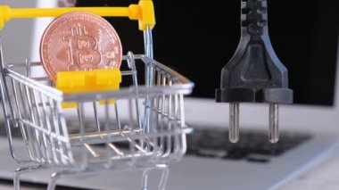 Kripto para birimi Bitcoin ve güç kaynağı soketi. El tutuş tıpasında bilgisayar monitörü, fişten çekilen bitcoin makinesi var. Yüksek oranda çıkarılan BTC kripto para birimi