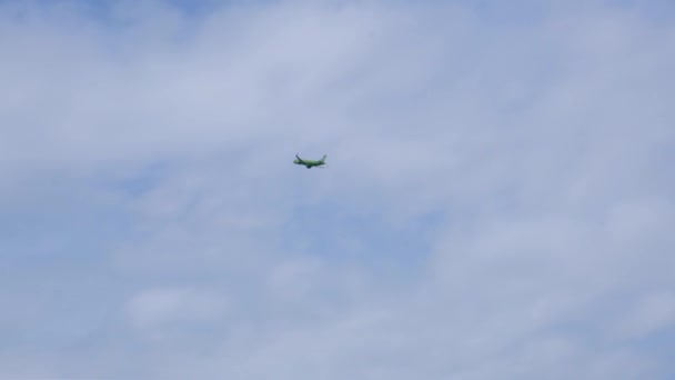 Силуэт Современный большой самолет летает в небе. Красивое голубое небо и белые облака на заднем плане. Самолет пролетает над головой. Самолет взлетает или садится — стоковое видео